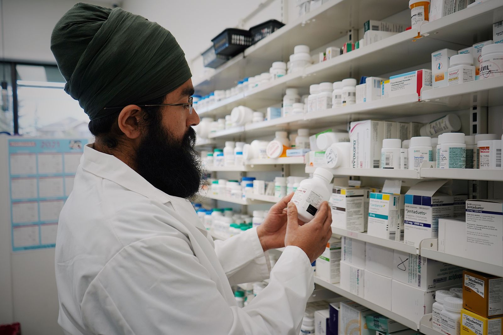 Pharmacist reviewing stock on dispensing shelves